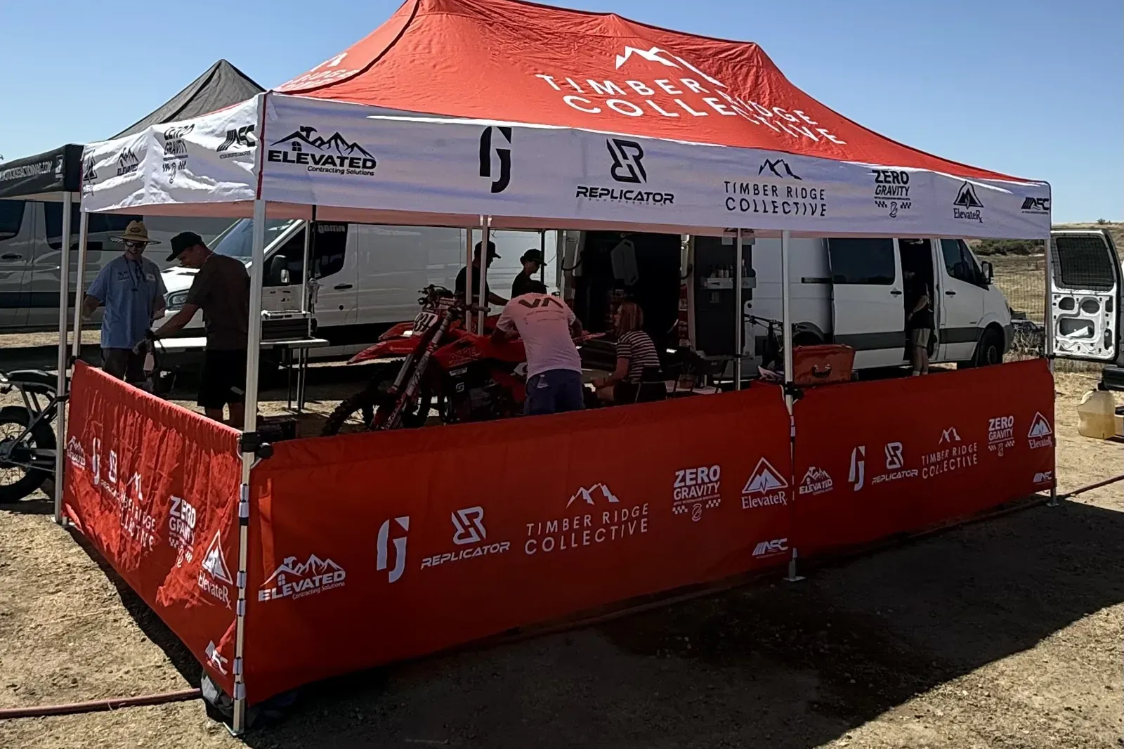 The Timber Ridge Collective tent in the pits, its walls lined with partner logos